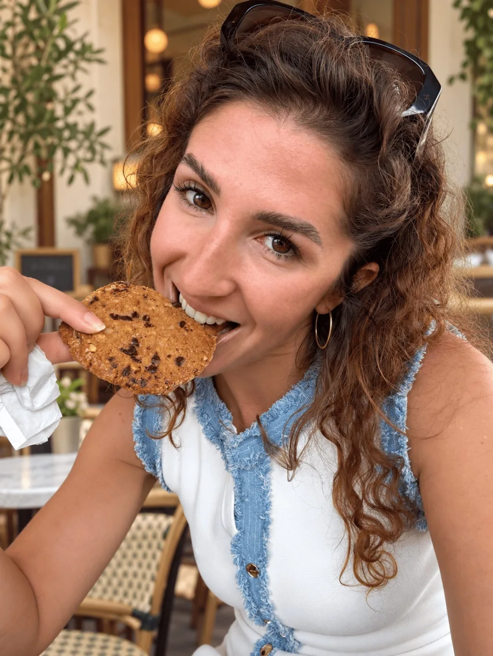 Floriane qui croque dans un cookie à la terrasse d'un café